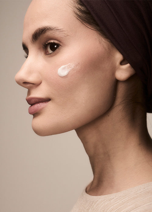 Woman with cream on her cheek