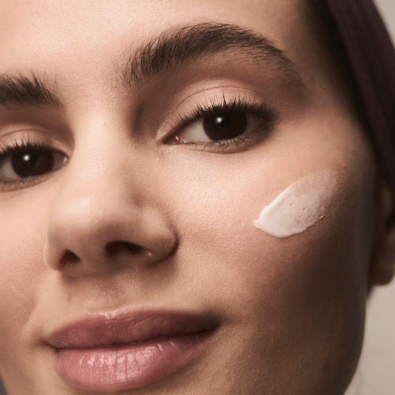 Woman with cream on her cheek