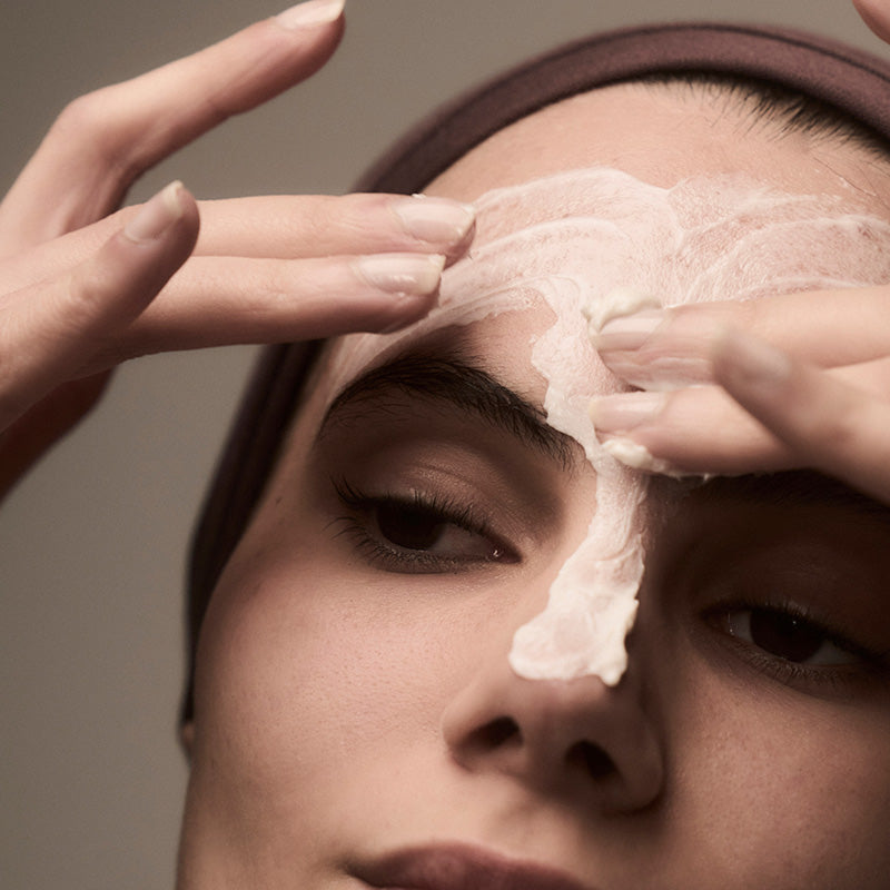 woman putting cream on her face