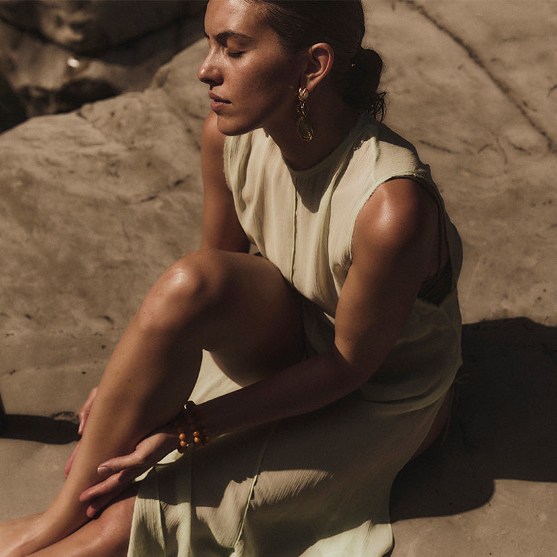 Woman with beige dress sitting in the sun
