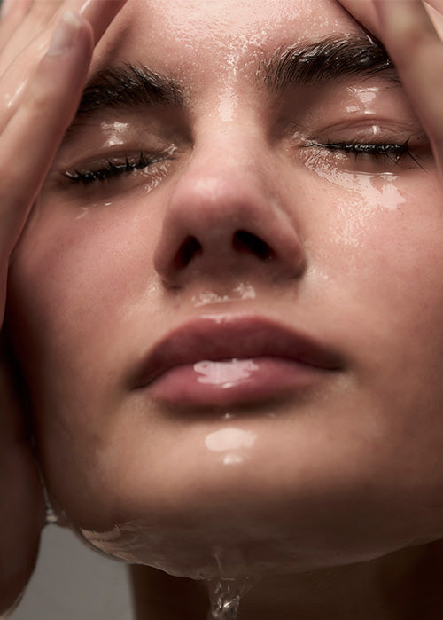 Woman washing her face close up
